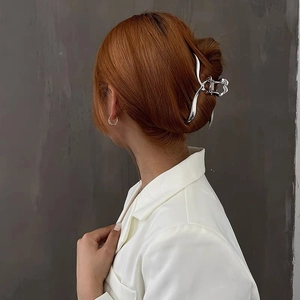 Silver metal hair claw clip with mirror finish shown on model with reddish brown hair