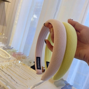 Detailansicht gepolsterter Schwamm-Haarreifen mit HAND MADE-Label und Webstruktur