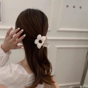 Elegant matte white flower hair claw clip for women in a half-up hairstyle