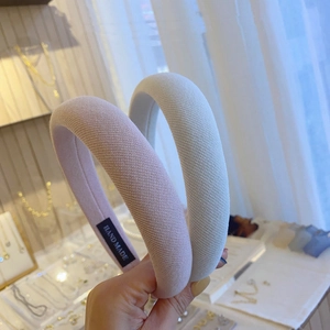 Nahaufnahme handgefertigter, cremefarbener gepolsterter Haarreifen mit weichem Strickstoff