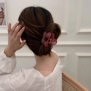 Pink translucent flower hair claw clip shown worn in a stylish bun on a model
