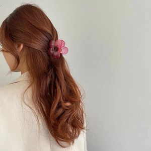 Pink floral claw clip shown on long wavy hair for a stylish hair accessory look
