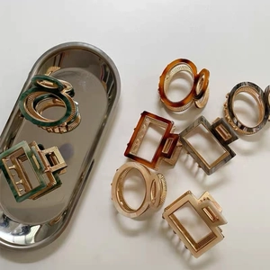 Detailed macro view of vintage acetate hair claws in various colors on a silver tray