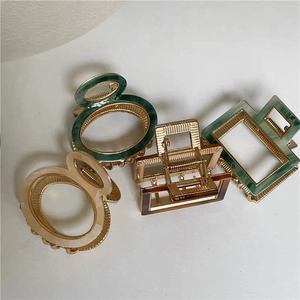 Set of four vintage acetate hair claws in green, cream, and amber marble patterns