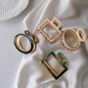 Elegant tortoiseshell hair clips with gold frames on silk background set of four pieces