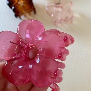 Detail showing high-quality bright pink floral hair claw clip made of acrylic resin