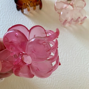 Close-up of rose red translucent flower hair claw clip with smooth acrylic texture