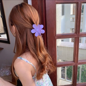 Pince à cheveux fleur violet clair au fini mat portée sur une coiffure mi-haute