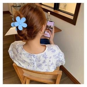 Pince à cheveux fleur bleue portée par un mannequin dans un décor de style de vie