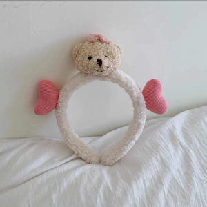 Close-up of plush bear headband with pink knit hearts for face washing and skincare