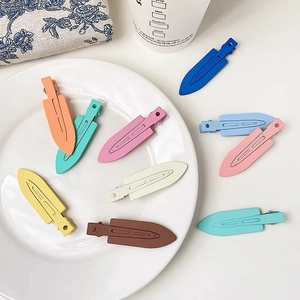 Λήψη flat lay από πολύχρωμα ματ κλιπ μαλλιών σε λευκό κεραμικό πιάτο και φλοράλ ύφασμα