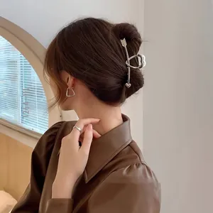 Pince à cheveux flèche de Cupidon argentée et boucles d'oreilles triangle sur modèle