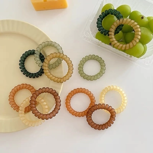 Élastiques à cheveux mat type fil de téléphone aux couleurs Morandi sur assiette