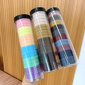 Detailed close-up of high elasticity hair ties in clear jars with textured knit patterns