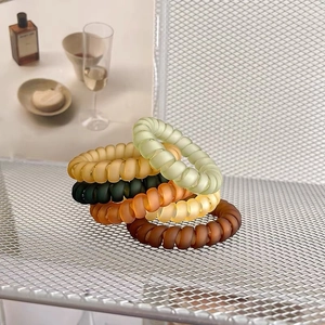 Lot de 5 élastiques à cheveux spirales mats aux tons terre sur support métallique blanc
