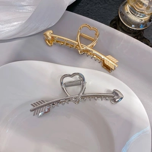 Détail de pinces à cheveux flèche de Cupidon en or et argent avec ressort métallique robuste