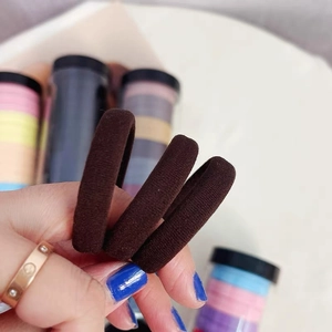 Close-up of thick seamless high-elastic hair ties with dense knitted texture in dark brown