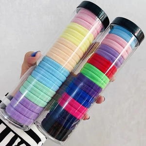 Close-up of colorful plush hair ties stored in a transparent cylinder container