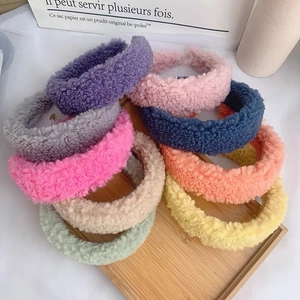 Detailed view of colorful plush lamb wool headbands neatly arranged on a wooden tray