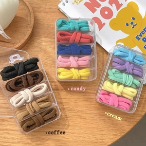 Detailed view of high-elasticity hair ties in candy and coffee tones with storage boxes