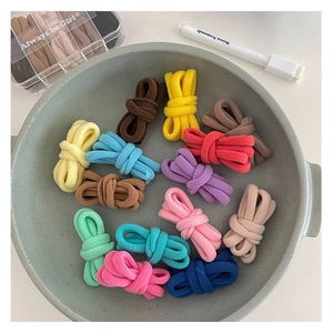 Close-up of vibrant multi-colored thick high-elastic hair ties in a ceramic bowl