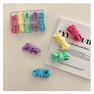 Detail of five-grid storage box with colorful macaron elastic hair ties in pastel colors