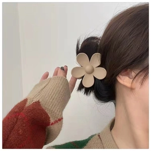 Matte milk tea flower hair claw clip shown in a stylish side view on wavy hair