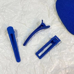 Detailed view of matte Klein Blue hair clips set on a clean textured background