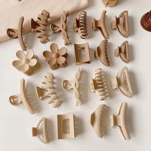 Flat lay of matte hair claws in cream and beige tones with various geometric designs