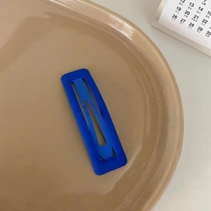 Matte Klein blue rectangular BB hair clip on a minimalist ceramic tray background