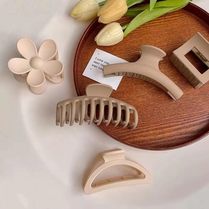 Detailed macro view of matte neutral hair claws in assorted minimalist geometric shapes