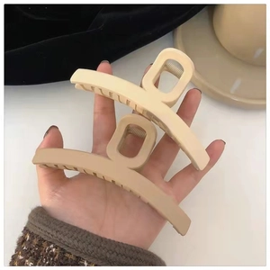 Close-up of matte cream hair claws in a hollow design for thick hair styling