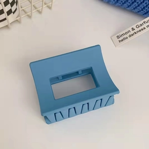 Dettaglio del fermaglio per capelli quadrato blu chiaro opaco su sfondo lifestyle