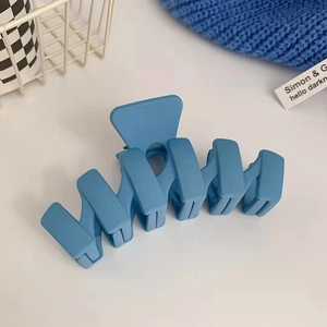 Dettaglio di una pinza per capelli blu Klein opaca con una texture satinata