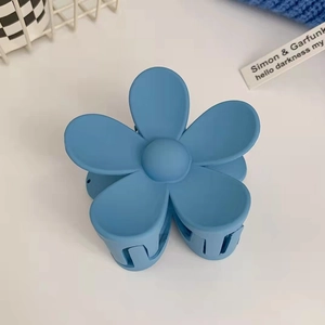 Dettaglio del fermaglio per capelli a fiore blu opaco su uno sfondo estetico