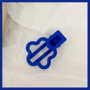 Vue détaillée d'une pince à cheveux fleur bleu Klein ajourée avec finition mate