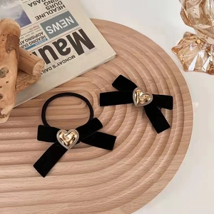 Détail du nœud de cheveux en velours noir et élastique avec cœur en métal doré