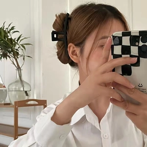 Minimalist matte black rectangular hair claw clip for women in a natural side-view hairstyle