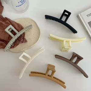 Detailed overhead view of six matte hair claw clips in assorted neutral earth tones