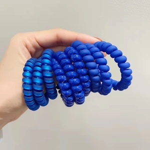 Vue détaillée d'élastiques à cheveux spirales bleus avec finitions mates et brillantes