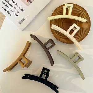 Collection of large matte hair claws in neutral colors including cream, khaki, and olive green