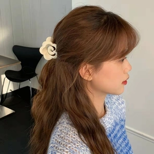 Elegante molletta per capelli a fiore bianco indossata da una modella, finitura opaca