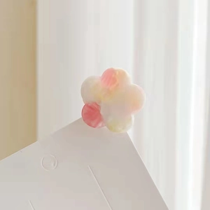 Nahaufnahme einer kleinen Acetat-Blumen-Haarklammer mit rosa Farbverlauf auf weißer Karte