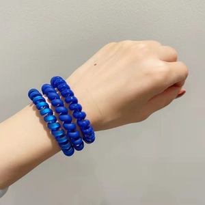 Trois élastiques à cheveux spirales bleus avec finitions mates et transparentes