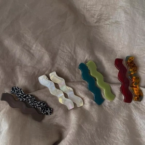 Barrettes à cheveux élégantes en acrylique ondulé multicolores sur fond en tissu neutre