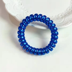 Gros plan sur l'élastique cheveux spirale bleu brillant avec finition métallique sur plat