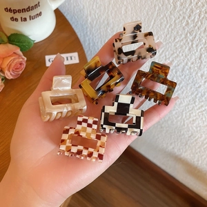 Close-up of small acetate hair claws in leopard and checkerboard patterns