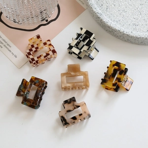 Flat lay of small square acetate hair claws in leopard and checkerboard patterns