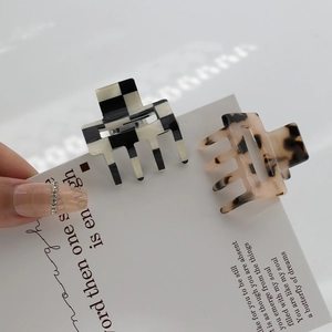 Square acetate hair claws featuring checkerboard and leopard patterns for elegant styling