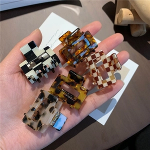 Close-up of five mini square acetate hair claws featuring leopard and checkered patterns